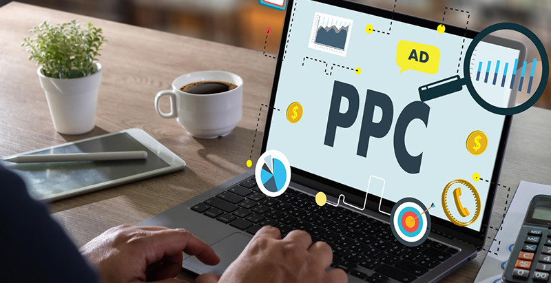 Person typing on a laptop showing a Pay-Per-Click PPC marketing dashboard beside coffee.